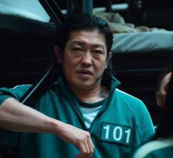 Male participant in green tracksuit with strong build and aggressive posture